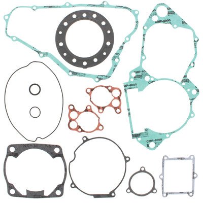 Assortment of engine gaskets in various shapes and sizes laid out on a white background, including turquoise and copper pieces and circular rings.