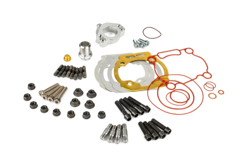 Assorted automotive hardware including gaskets, bolts, nuts, and red hoses laid out on a white background.